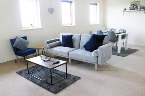 a living room with a couch and a table at 2 bed flat near Milton Keynes city centre in Milton Keynes
