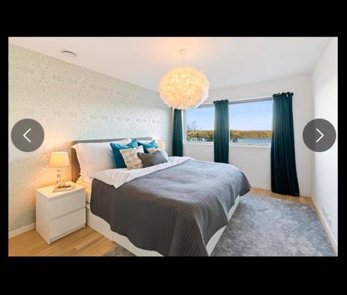 a bedroom with a large bed and a window at Moderne funkis med fantastisk havutsikt in Asker