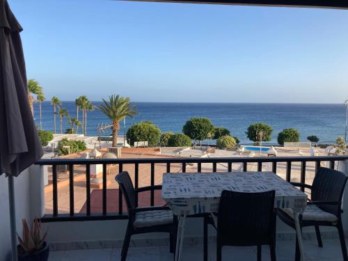 a balcony with a table and chairs and the ocean at Apartamento Verena in Puerto del Carmen