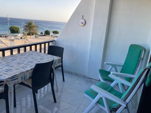 a balcony with a table and chairs and the ocean at Apartamento Verena in Puerto del Carmen