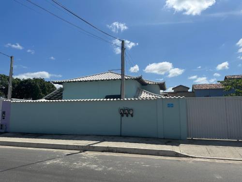uma cerca branca em frente a uma casa em Casa Onda Azul 1 em Saquarema