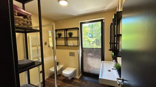 a bathroom with a toilet and a sink and a window at Budka in Hradištko