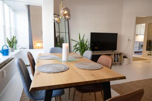 Un comedor con una mesa de madera con sillas. en Stefania, en Aalborg