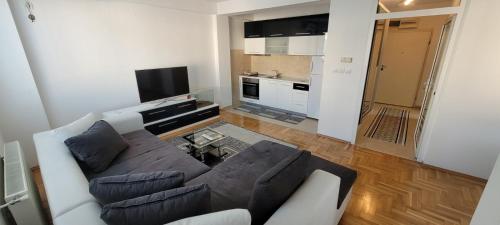 a living room with a couch and a kitchen at Vodno Central Modern Flat M&M Apartments in Skopje