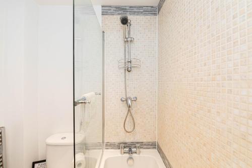 een badkamer met een douche en een wit toilet bij Ocean Breeze - 1 MINUTE FROM THE BEACH - 10 MINUTE FROM BIC - FAST WI-FI - SMART TV in Bournemouth
