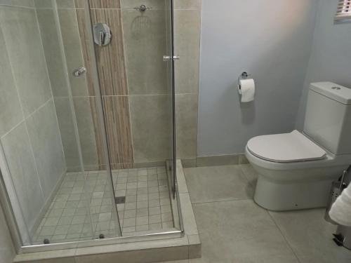 a bathroom with a shower and a toilet at REALJOY GUEST SUITES in Centurion