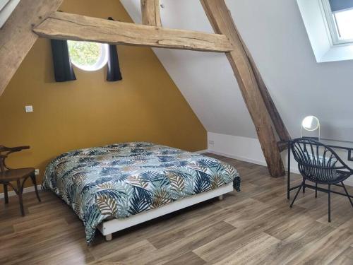 une chambre avec un lit dans un grenier dans l'établissement Location maison proche mer, à Canville-les-Deux-Églises