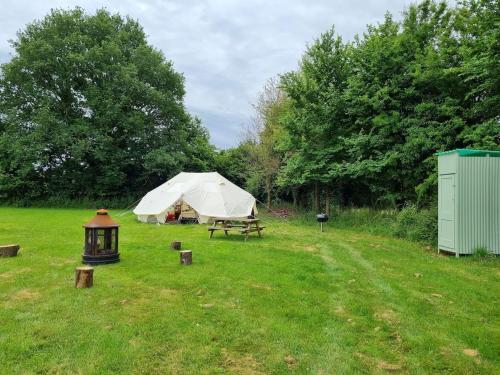 ein Zelt und ein Picknicktisch auf einem Feld in der Unterkunft Glamping in style Emperor tent in Ifield