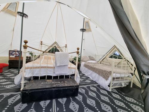 1 dormitorio con 2 camas en una tienda de campaña en Glamping in style Emperor tent en Ifield