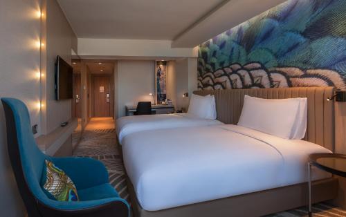 a bedroom with a large white bed and a blue chair at DoubleTree by Hilton Istanbul - Sirkeci in Istanbul