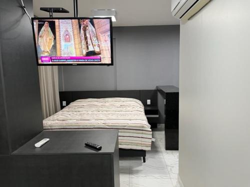 Cette chambre comprend un lit et une télévision à écran plat. dans l'établissement Apartamento de luxo no Hotel Stop-Inn Cristiano Machado, à Belo Horizonte