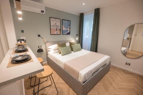Schlafzimmer mit einem Bett, einem Tisch und einem Spiegel in der Unterkunft Monte 21 - San Giusto in Triest