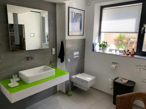 Ferienoase zwischen Rostock und Warnemünde في روستوك: حمام مع حوض ومرحاض