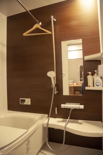 a bathroom with a tub and a sink and a mirror at 東寺楽屋 Toji Rakuya in Kyoto