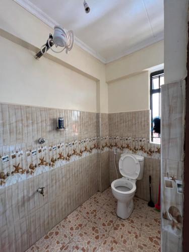 a bathroom with a toilet and a shower at Exquisite Modern suite 1bedroom in Busia