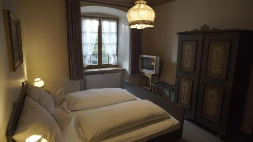 a bedroom with two beds and a window and a chandelier at Fährhaus Hotel in Waldshut-Tiengen