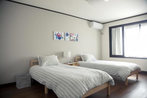a bedroom with two beds and a window at 東寺楽屋 Toji Rakuya in Kyoto