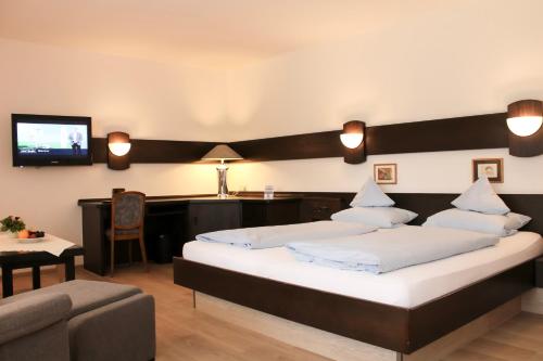 ein Schlafzimmer mit 2 Betten, einem Sofa und einem TV in der Unterkunft Hotel Stockhausen GbR in Schmallenberg