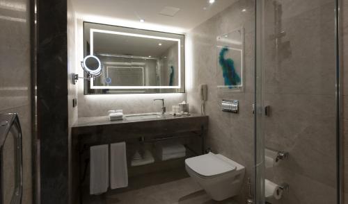 a bathroom with a sink and a toilet and a mirror at DoubleTree by Hilton Istanbul - Sirkeci in Istanbul