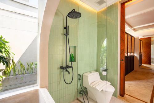 a bathroom with a shower and a toilet at The Kemilau Hotel & Villa Canggu Bali in Canggu