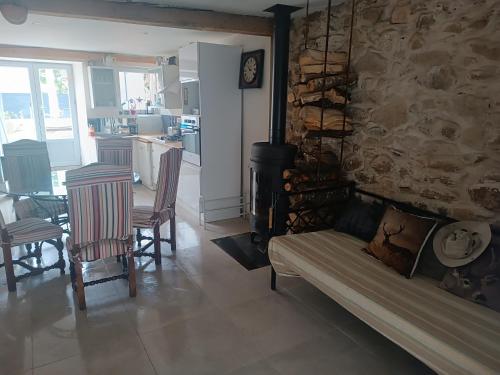 un salon avec un canapé et un mur en pierre dans l'établissement Charmante maison village QUERIGUT, à Quérigut