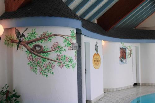 a wall with a painting of a bird on a branch at Hotel Stockhausen GbR in Schmallenberg