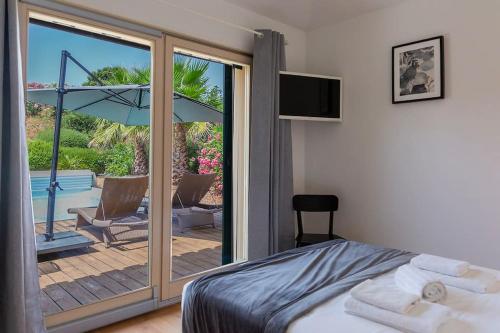 a bedroom with a bed and a sliding glass door at Les Hameaux De Buttaciolo in Cuo