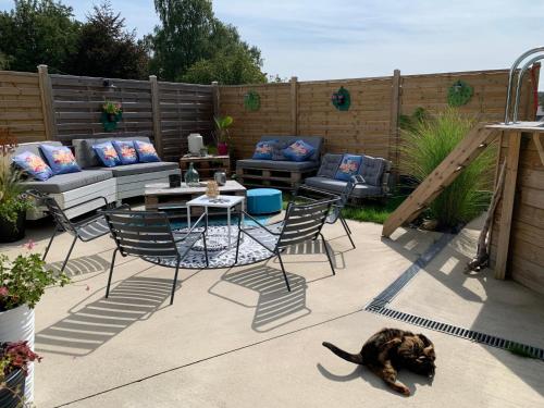 a cat laying on a patio with a table and chairs at Chez Isa in Faymonville