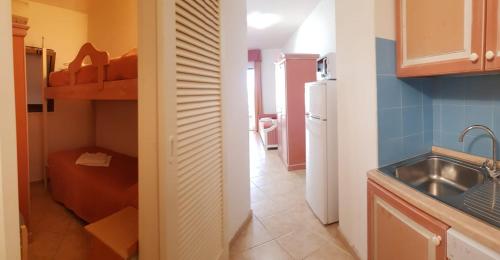 a small kitchen with a sink and a refrigerator at Residence Hotel Nuraghe in Porto Rotondo