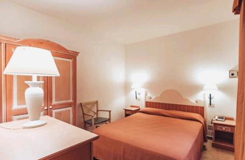 una camera d'albergo con letto e lampada di Residence Hotel Nuraghe a Porto Rotondo