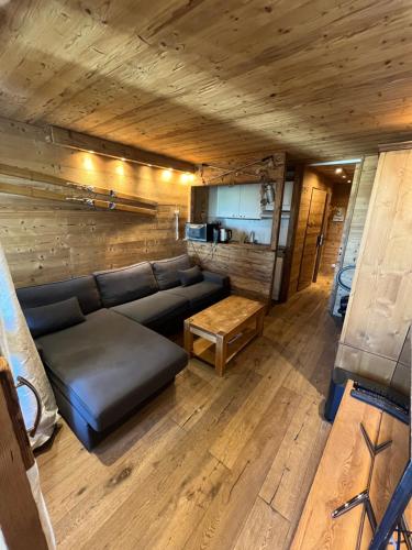 a living room with a couch and a table at APT centre station vue sur les pistes de Val Thorens 6p in Val Thorens