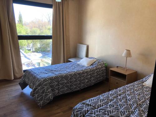 Habitación de hotel con 2 camas y ventana en Departamento Residencial en Capital Mendoza. en Mendoza