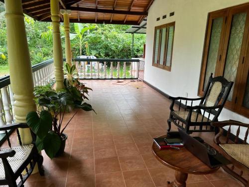 a living room with chairs and a table and a porch at Vegan Nature Resort in Beruwala