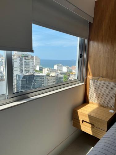 1 dormitorio con ventana y vistas a la ciudad en Rio Flat Leblon, en Río de Janeiro
