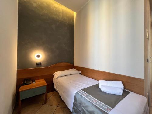 a small bedroom with two beds and a table at Hotel Sara in Milan