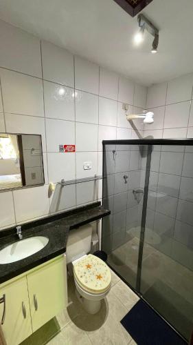 a bathroom with a toilet and a sink and a mirror at Maragogi, LiaMara Accommodations in Maragogi