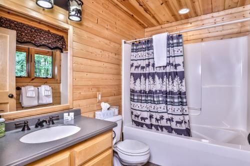 a bathroom with a toilet sink and a shower curtain at Woodland Wonderland in Winchester
