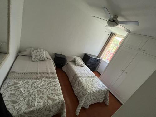 sypialnia z 2 łóżkami i wentylatorem sufitowym w obiekcie Jacaranda, todo lo que necesitas para tus vacaciones w Playa de las Americas
