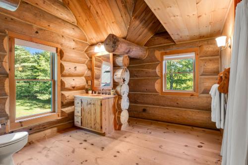 baño de madera con aseo y ventanas en Spruce Moose Lodge, en Hartland