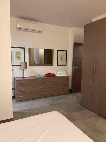 1 dormitorio con tocador y espejo grande en Appartamento Montegrappa in centro a Varese, en Varese