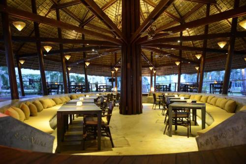 een restaurant met tafels en stoelen en een groot plafond bij @beach village in Sam Roi Yot