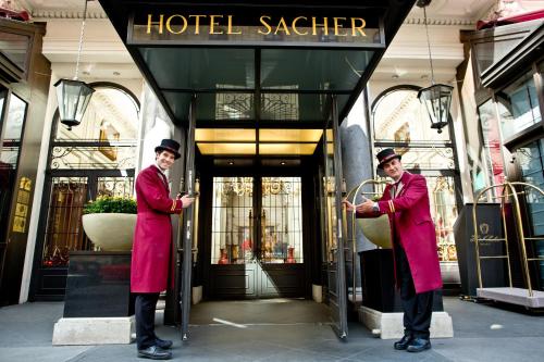 two men standing in front of a hotelstaater building at Hotel Sacher Wien in Vienna