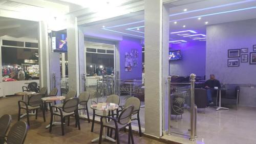 達赫拉的住宿－HOTEL NASSIM AL-BAHR，餐厅设有桌椅和紫色墙壁