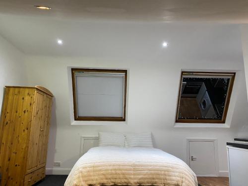 a bedroom with a bed and a window at Studio Flat in Hatch End