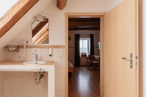 a bathroom with a sink and a mirror at Zum Spitzbuam in Attenkirchen