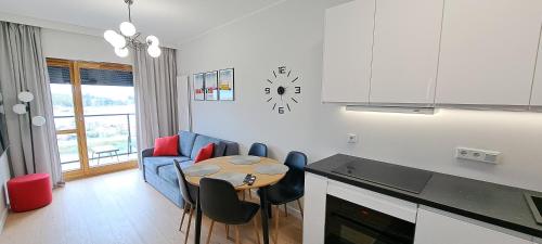 Una cocina y una sala de estar con mesa y sillas. en Apartment No 235, en Gdansk