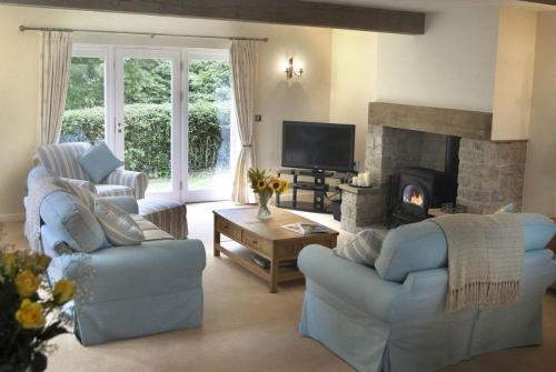 sala de estar con 2 sillas y chimenea en Lake Cottage , Middleton Hall Estate en Smeafield