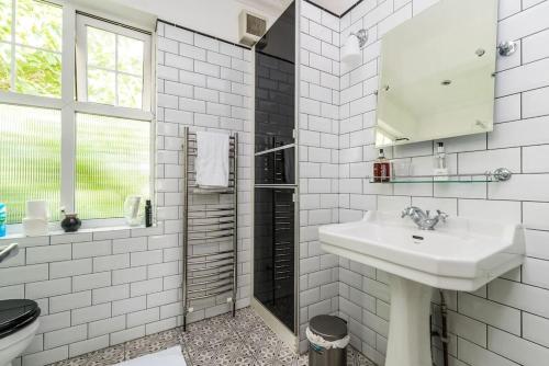 Baño blanco con lavabo y aseo en Modern and Spacious 2 bed in Brixton, en Londres