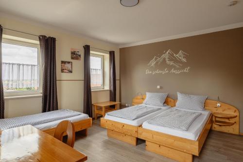 a bedroom with two beds and a table at Zum Spitzbuam in Attenkirchen