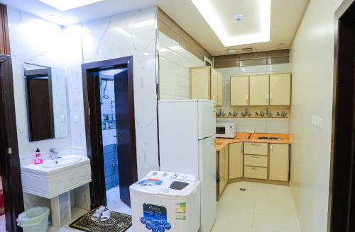 a small kitchen with a sink and a refrigerator at شقق مساكن الاطلال الفندقيه in Riyadh
